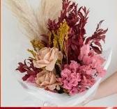 Arranjo de flores desidratadas em tons de vinho e rosa